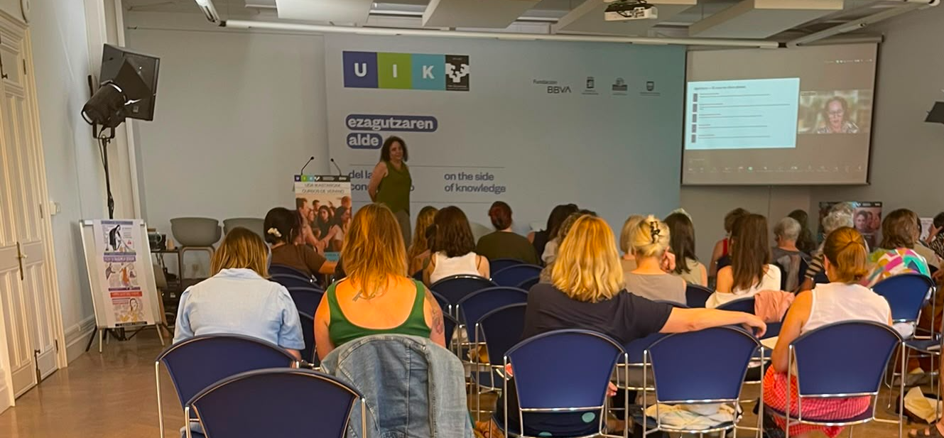 Sala del curso de verano de UIK con el público de espaldas y Raquel Bouza-Brey al fondo, junto al panel institucional de UIK y la Fundación BBVA